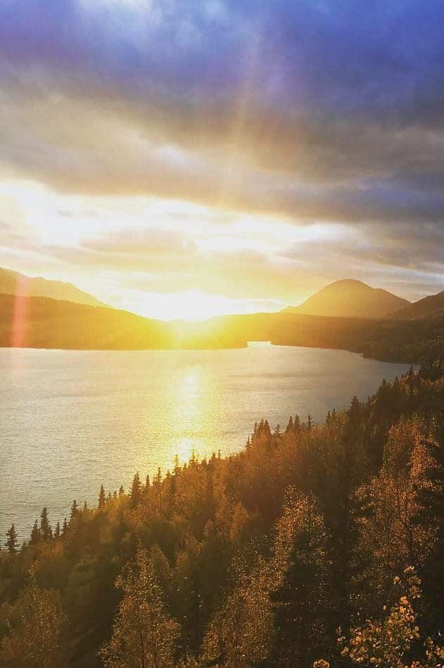 Sunset over Kenai River with mountain backdrop and autumn foliage scenery.