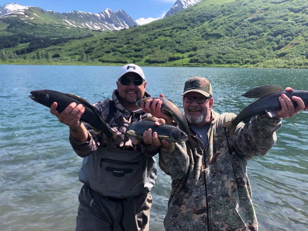 Two anglers proudly display their catches on a fly-in fishing trip in the scenic Kenai Peninsula, Alaska.