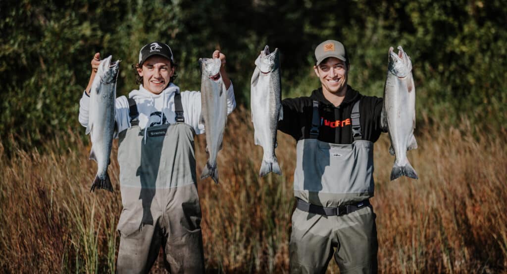 2 clients holding up a limit of silver salmon.