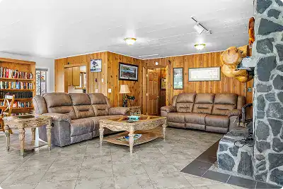 Cozy lodge living room with leather sofas and wooden accents at Kenai River Drifters Lodge.