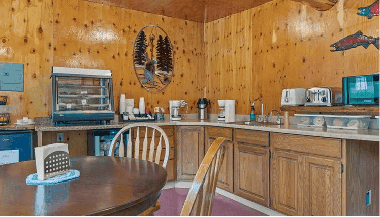 Cozy kitchen area at Kenai River Drifters Lodge with wooden cabinets and rustic decor.