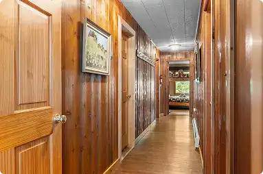 Cozy wooden hallway at Kenai River Drifters Lodge with warm lighting and rustic decor.