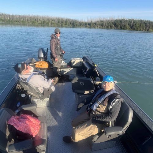Fishing boat on the Kenai River with three people enjoying a day of fishing in Alaska.