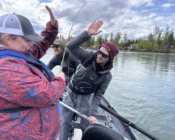 Fishing group celebrating catch on the boat in Kenai River, Alaska.