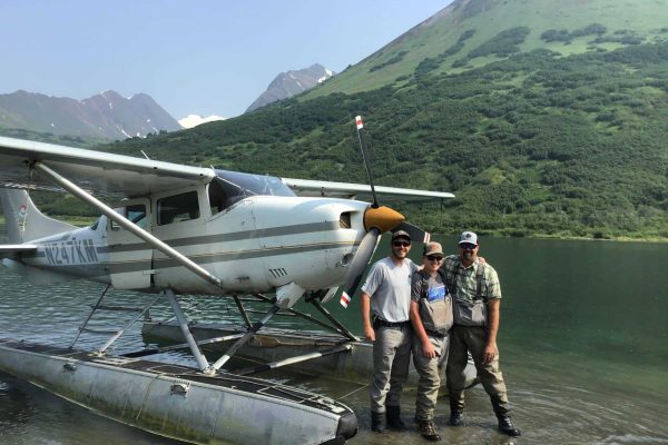 Clients standing with guide in front of float plane | Experience Fly In Fishing Trips For Arctic Grayling